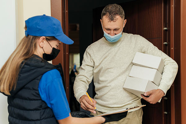 Repartidor entregando un paquete a un cliente en su puerta